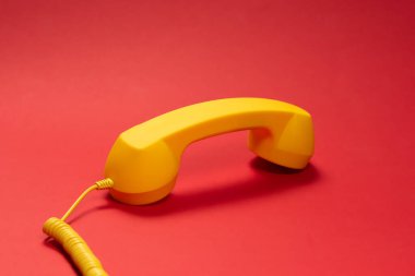 Kırmızı arka planda sarı cep telefonu. Boşluğu kopyala. 