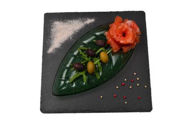 Beyaz üzerine tuz ve zeytinli bir tabakta somon dilimleri..