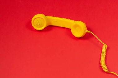 Kırmızı arkaplanda sarı cep telefonu. 