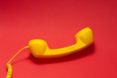 Kırmızı arka planda sarı cep telefonu. Boşluğu kopyala. 