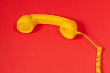 Kırmızı arkaplanda sarı cep telefonu. 