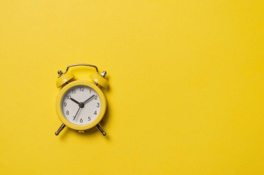Sarı arka planda sarı alarm saati. Uzayı kopyala Zaman kavramı. Boşluğu kopyala. 