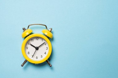 Mavi arka planda sarı alarm saati. Uzayı kopyala Zaman kavramı. 