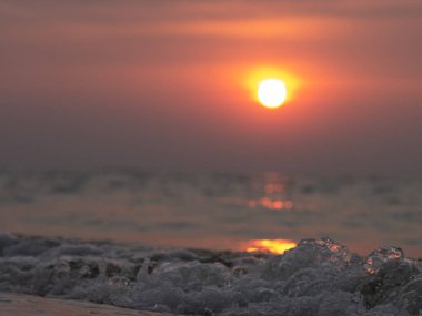 Sahilde güzel bir gün batımı. Yaz günbatımı ve deniz dalgaları