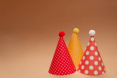 Kahverengi arka planda renkli bir doğum günü şapkası. Boşluğu kopyala. 