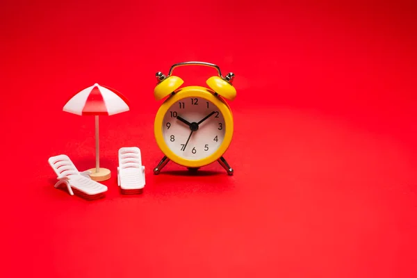 Hora Viajar Espreguiçadeira Guarda Chuva Despertador Fundo Vermelho — Fotografia de Stock