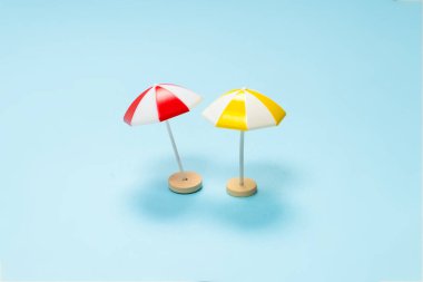 Mavi arka planda sarı ve kırmızı şemsiye. Boşluğu kopyala.