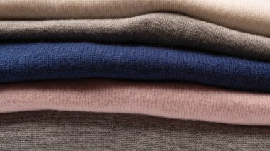 Beyaz arka planda izole edilmiş bir grup kalın kazak. Beyaz arkaplanda katlanmış süveter yığını.