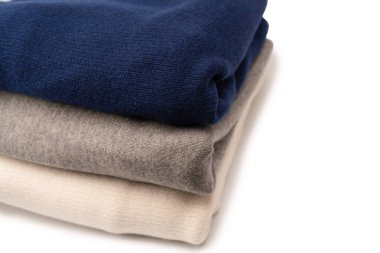 Beyaz arka planda izole edilmiş bir grup kalın kazak. Beyaz arkaplanda katlanmış süveter yığını.