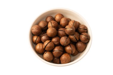 Beyaz arka planda izole edilmiş kabuklu Macadamia fındıkları. Üst görünüm.