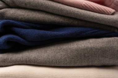 Beyaz arka planda izole edilmiş bir grup kalın kazak. Beyaz arkaplanda katlanmış süveter yığını.