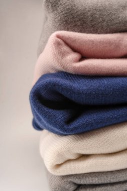 Beyaz arka planda izole edilmiş bir grup kalın kazak. Beyaz arkaplanda katlanmış süveter yığını.