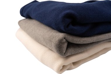 Beyaz arka planda izole edilmiş bir grup kalın kazak. Beyaz arkaplanda katlanmış süveter yığını.