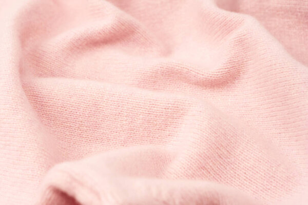 Смазанный розовым кашемировым свитером фон. Вид сверху. 