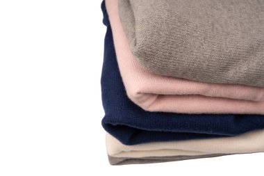 Beyaz arka planda izole edilmiş bir grup kalın kazak. Beyaz arkaplanda katlanmış süveter yığını.