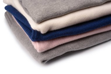 Beyaz arka planda izole edilmiş bir grup kalın kazak. Beyaz arkaplanda katlanmış süveter yığını.