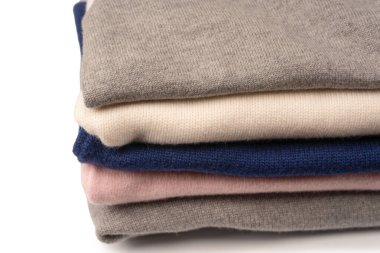 Beyaz arka planda izole edilmiş bir grup kalın kazak. Beyaz arkaplanda katlanmış süveter yığını.