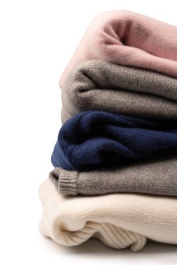 Beyaz arka planda izole edilmiş bir grup kalın kazak. Beyaz arkaplanda katlanmış süveter yığını.