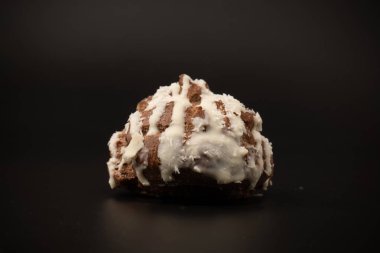 Siyah arka planda hindistan cevizi kremalı profiterol.. 