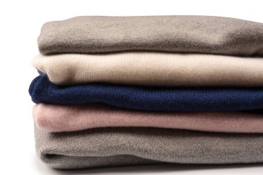 Beyaz arka planda izole edilmiş bir grup kalın kazak. Beyaz arkaplanda katlanmış süveter yığını.