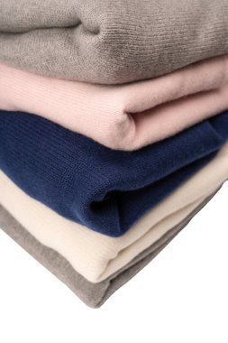 Beyaz arka planda izole edilmiş bir grup kalın kazak. Beyaz arkaplanda katlanmış süveter yığını.