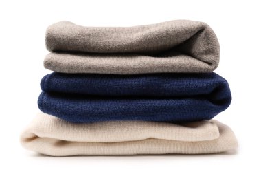 Beyaz arka planda izole edilmiş bir grup kalın kazak. Beyaz arkaplanda katlanmış süveter yığını.