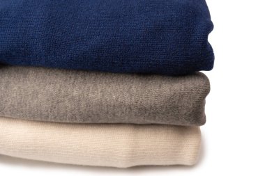 Beyaz arka planda izole edilmiş bir grup kalın kazak. Beyaz arkaplanda katlanmış süveter yığını.