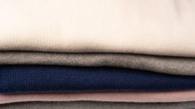 Beyaz arka planda izole edilmiş bir grup kalın kazak. Beyaz arkaplanda katlanmış süveter yığını.