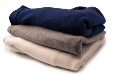 Beyaz arka planda izole edilmiş bir grup kalın kazak. Beyaz arkaplanda katlanmış süveter yığını.