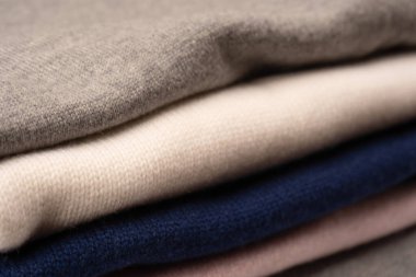 Beyaz arka planda izole edilmiş bir grup kalın kazak. Beyaz arkaplanda katlanmış süveter yığını.