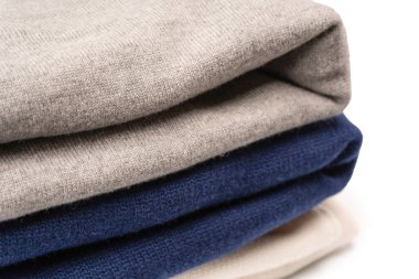 Beyaz arka planda izole edilmiş bir grup kalın kazak. Beyaz arkaplanda katlanmış süveter yığını.