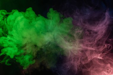 Siyah arka planda yeşil ve pembe buhar. Boşluğu kopyala.