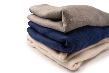 Beyaz arka planda izole edilmiş bir grup kalın kazak. Beyaz arkaplanda katlanmış süveter yığını.