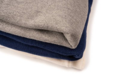 Beyaz arka planda izole edilmiş bir grup kalın kazak. Beyaz arkaplanda katlanmış süveter yığını.