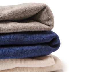 Beyaz arka planda izole edilmiş bir grup kalın kazak. Beyaz arkaplanda katlanmış süveter yığını.