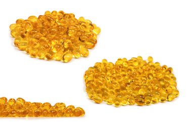 Beyaz zemin üzerinde izole edilmiş bir grup sarı kapsül.