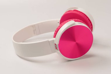 Pembe ve beyaz kulaklıklar beyaz arka planda izole edilmiş..