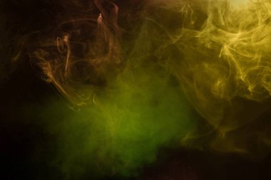 Siyah arka planda sarı ve yeşil buhar. Boşluğu kopyala.