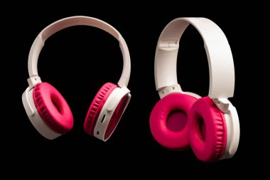 Siyah arkaplanda pembe ve beyaz kulaklıklar var..