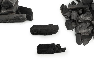 Beyaz arka planda siyah meşe kömürü izole edilmiş.