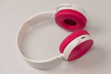 Pembe ve beyaz kulaklıklar beyaz arka planda izole edilmiş..