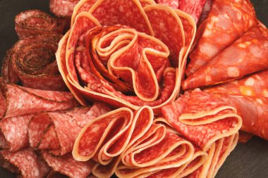 Tahtada farklı et parçaları var. Siyah bir arkaplanda.