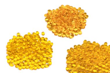 Beyaz zemin üzerinde izole edilmiş bir grup sarı kapsül.