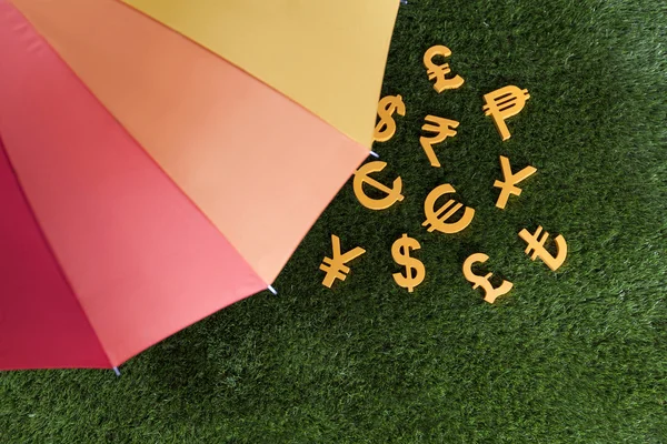 Цветной зонтик и деньги — стоковое фото