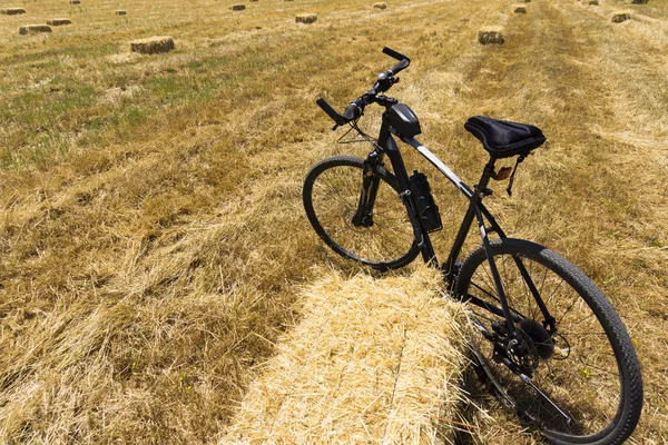 A mountain bike near hay bale in a field — Stock Photo, Image