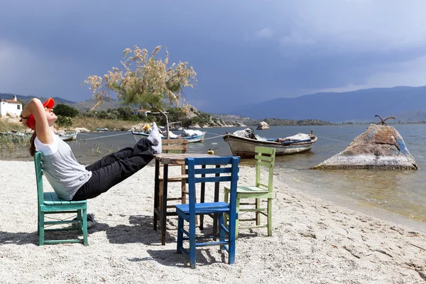 Woman is resting at characteristic restaurant on coast of the lake — Stock Photo, Image