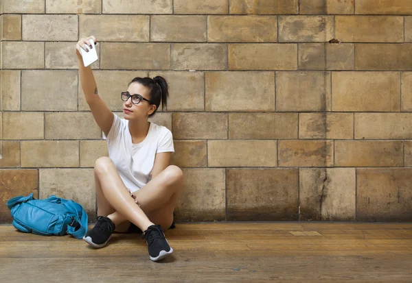 Młoda dziewczyna siedzi i co selfie — Zdjęcie stockowe