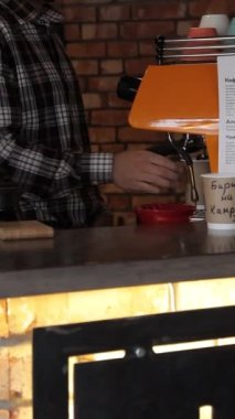 Kahve barmeni kahve yapmak için çalışıyor. Elden damlayan kahve turistleri ve damlayan kahve. Sıcak su döküyorum. Modern kafede sıcak içecek servisi..