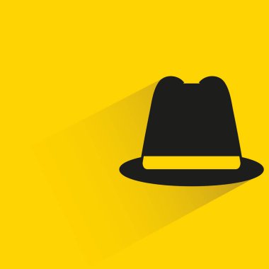 Sarı arka planda gölgesi olan şapka.