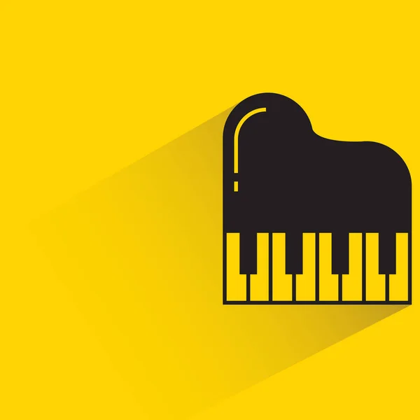 黄色の背景に影のあるピアノ — ストックベクタ
